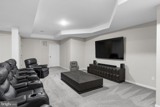 carpeted living area featuring visible vents, baseboards, and a tray ceiling