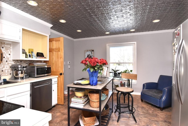 kitchen featuring stainless steel appliances, an ornate ceiling, light countertops, and crown molding