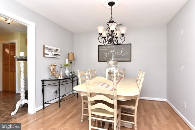 dining area with an inviting chandelier, baseboards, and wood finished floors