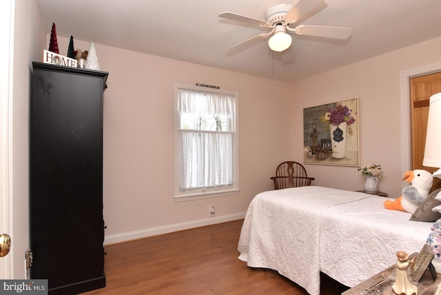 bedroom with wood finished floors, a ceiling fan, and baseboards