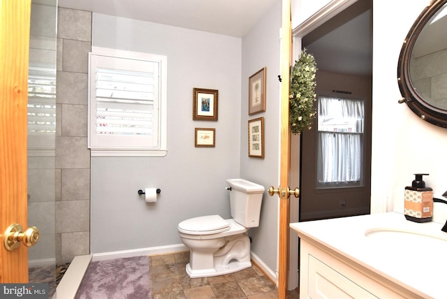 full bath with baseboards, vanity, and toilet