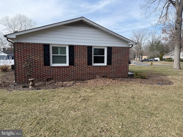 view of side of home with a yard and brick siding
