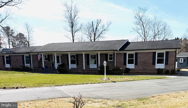 ranch-style house with a front yard, covered porch, and brick siding