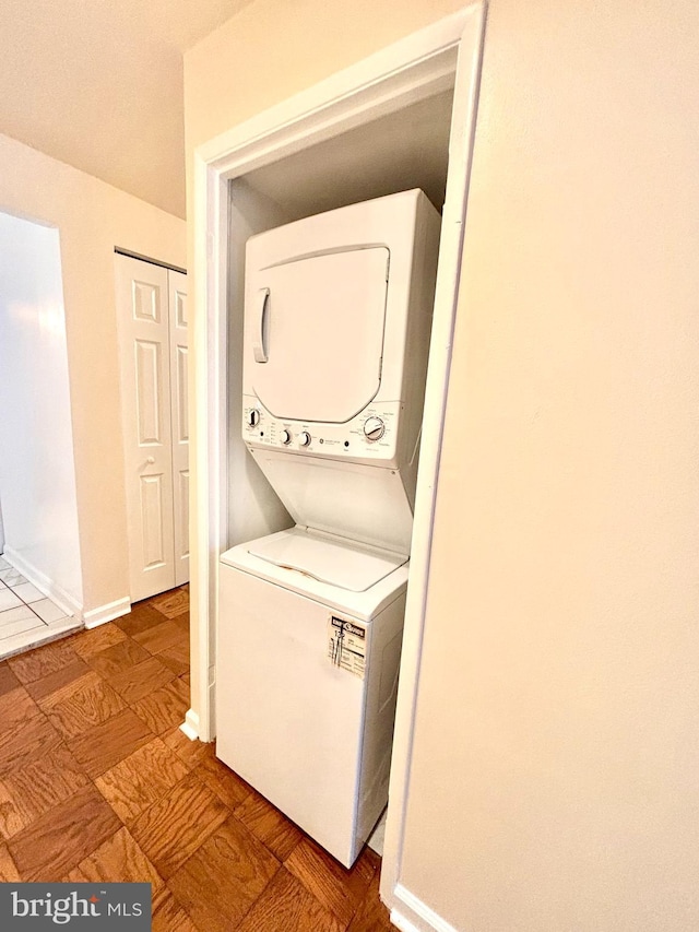 laundry area featuring stacked washer / drying machine