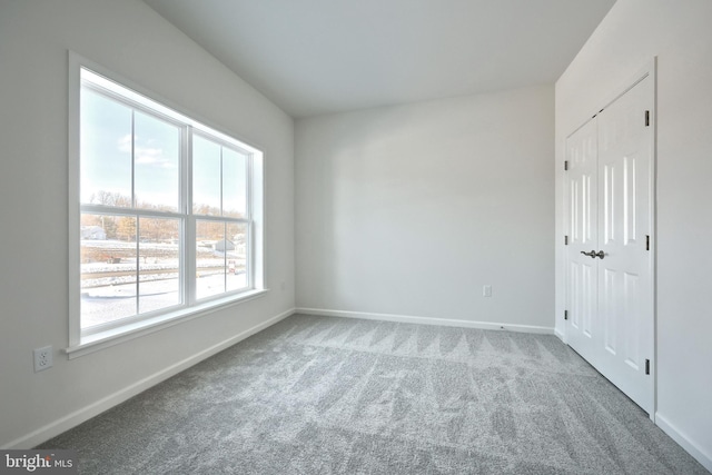 unfurnished bedroom with a closet, carpet flooring, and baseboards