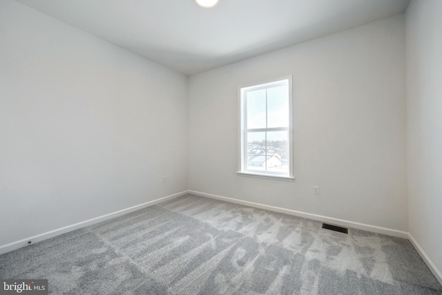 carpeted empty room with visible vents and baseboards