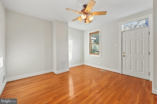 foyer entrance with a ceiling fan, light wood-type flooring, visible vents, and baseboards