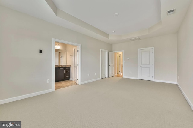 20765 Duxbury Ter, Ashburn, VA 20147 - unfurnished bedroom with light colored carpet, a raised ceiling, and ensuite bathroom