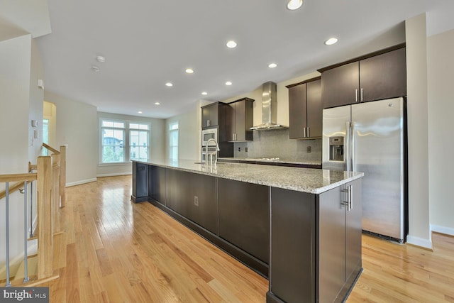 20765 Duxbury Ter, Ashburn, VA 20147 - kitchen with wall chimney range hood, stainless steel fridge with ice dispenser, a spacious island, light wood-style flooring, and recessed lighting