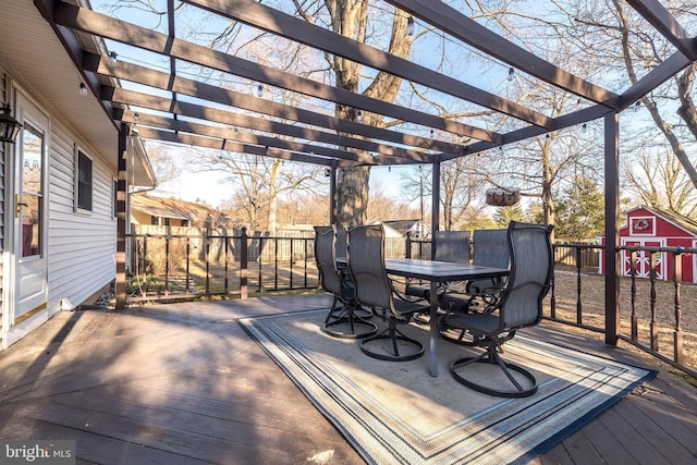 wooden terrace featuring a storage shed, outdoor dining space, an outdoor structure, and a pergola