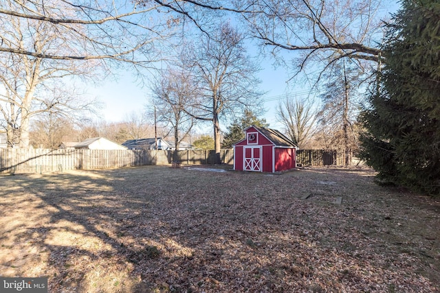 view of yard featuring fence private yard, a storage unit, and an outbuilding