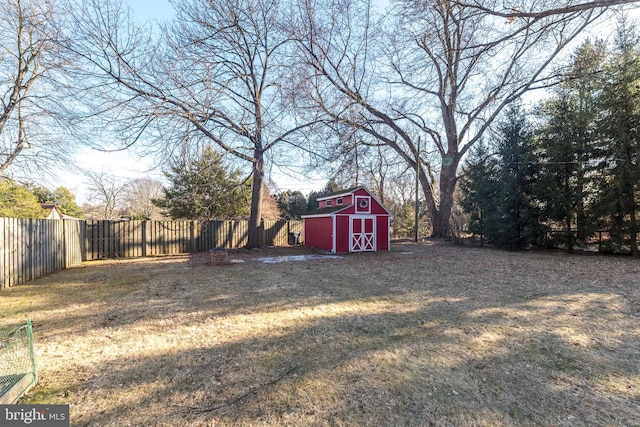 view of yard featuring a fenced backyard, an outdoor structure, and a shed