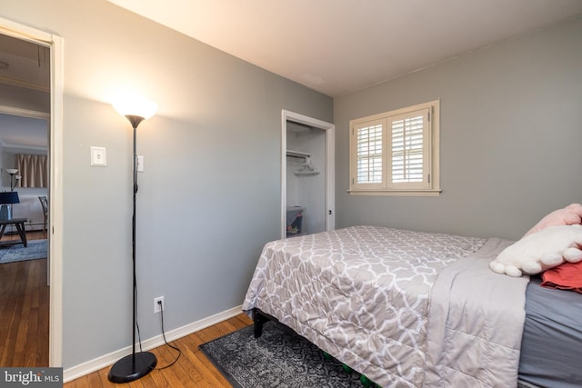 bedroom with a closet, baseboards, and wood finished floors