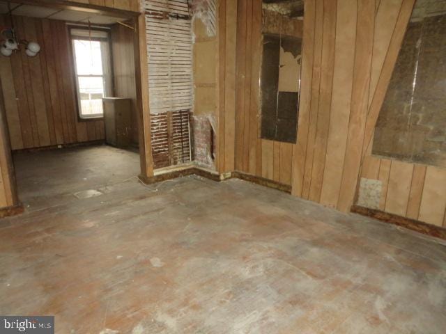 spare room featuring wood walls