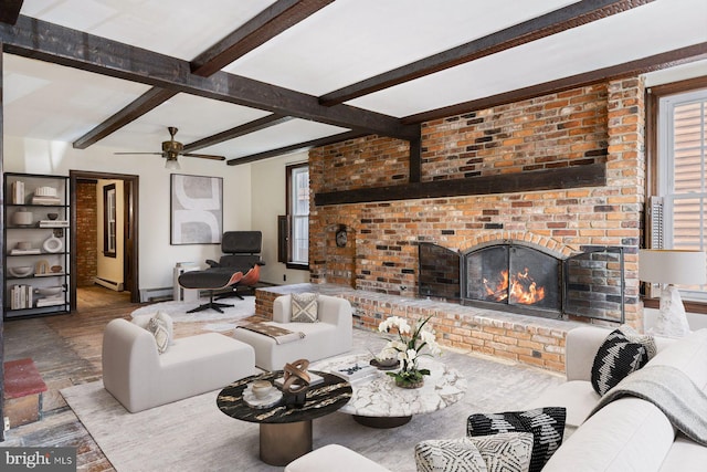 living room featuring beamed ceiling, a baseboard radiator, and a fireplace