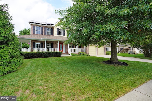 view of front of house with brick siding, solar panels, a front lawn, a porch, and concrete driveway