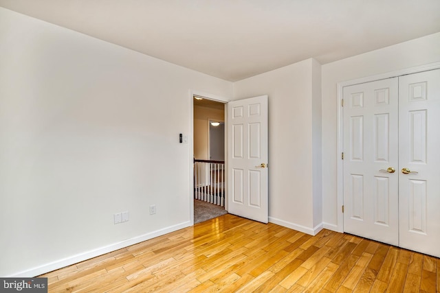 unfurnished bedroom featuring light hardwood / wood-style flooring and a closet