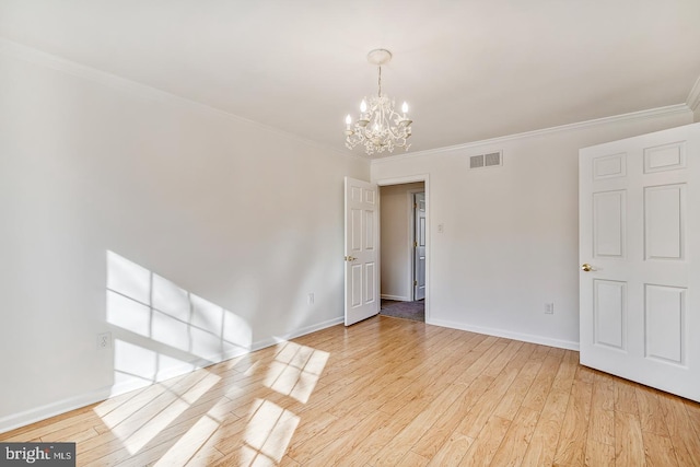 unfurnished room with crown molding, a chandelier, and light wood-type flooring