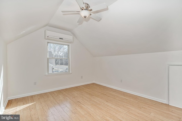 additional living space featuring ceiling fan, a wall mounted air conditioner, vaulted ceiling, and light wood-type flooring