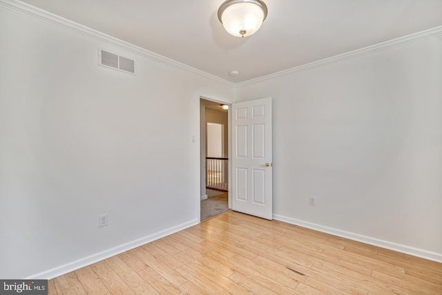 unfurnished room featuring ornamental molding and light hardwood / wood-style floors