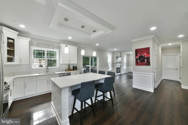 kitchen featuring sink, a center island, pendant lighting, stainless steel appliances, and white cabinets