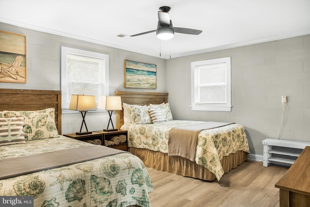 bedroom with multiple windows, crown molding, ceiling fan, and light hardwood / wood-style floors