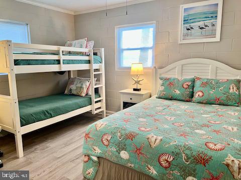 bedroom with crown molding and hardwood / wood-style floors