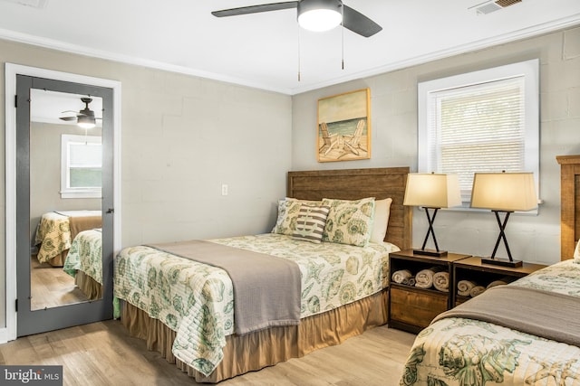 bedroom featuring light hardwood / wood-style flooring, ornamental molding, and ceiling fan