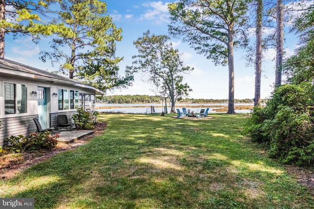 view of yard with a water view and a patio area