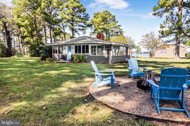 rear view of property featuring a sunroom and a yard