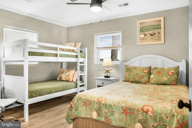 bedroom with ornamental molding, ceiling fan, and light wood-type flooring