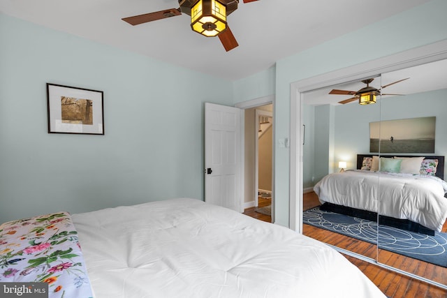 bedroom with ceiling fan, baseboards, and wood finished floors