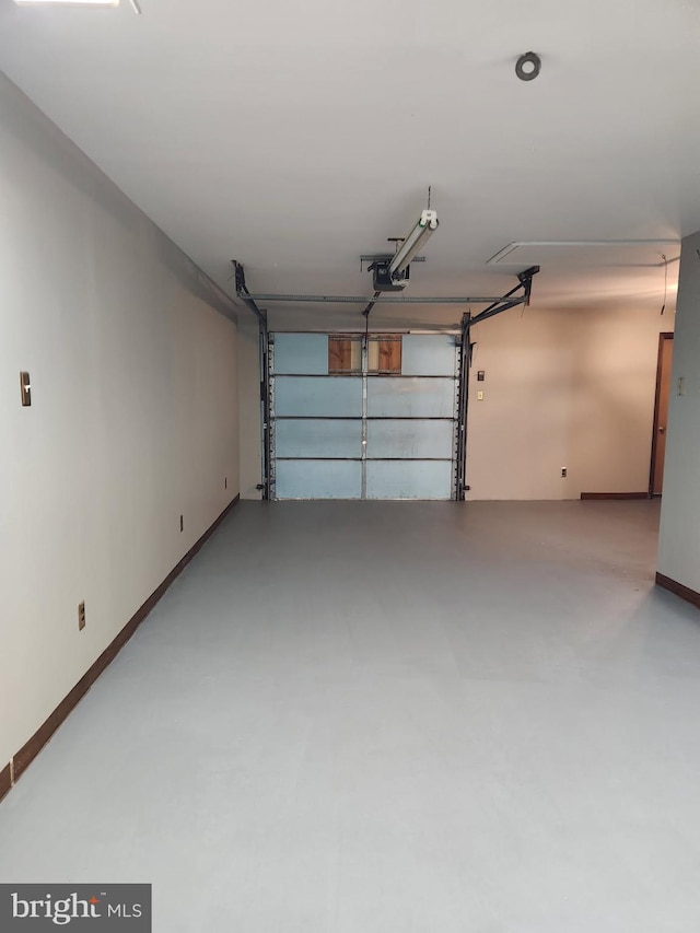 garage featuring a garage door opener and baseboards