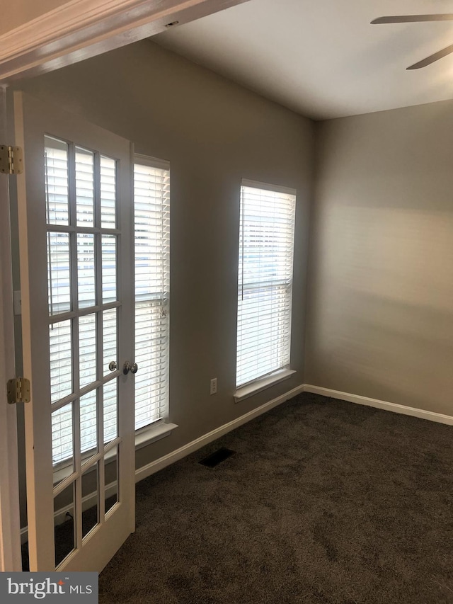 carpeted empty room with plenty of natural light, baseboards, visible vents, and ceiling fan