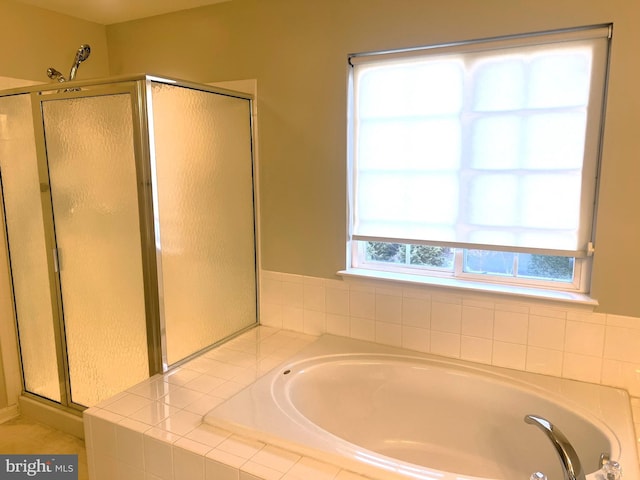 bathroom featuring a stall shower and a bath