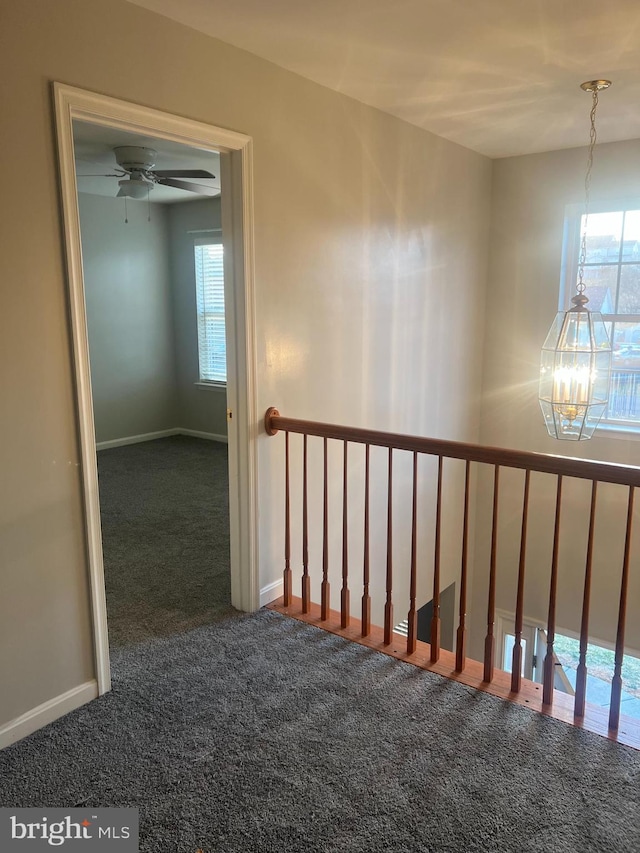 stairway featuring carpet flooring, ceiling fan with notable chandelier, and baseboards