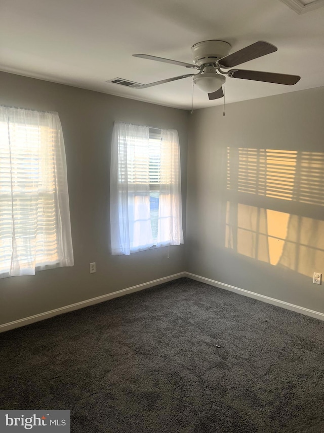 carpeted empty room featuring visible vents, baseboards, and a ceiling fan