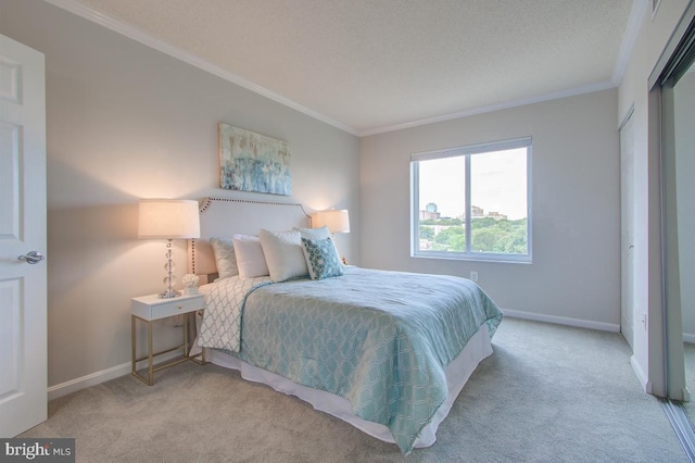 bedroom featuring baseboards, ornamental molding, a textured ceiling, and light colored carpet