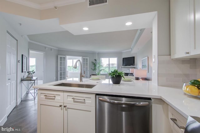 kitchen with light countertops, visible vents, stainless steel dishwasher, open floor plan, and a sink