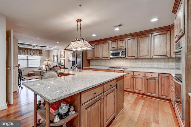 kitchen with open shelves, a sink, light wood-style floors, visible vents, and appliances with stainless steel finishes
