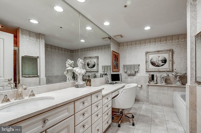 full bath with tile patterned flooring, a freestanding tub, recessed lighting, and vanity