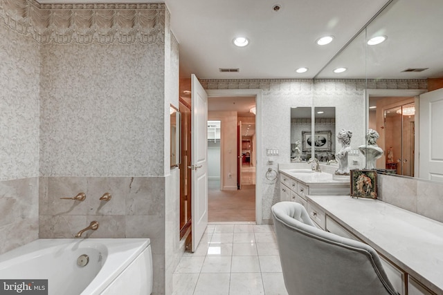 bathroom with vanity, tile walls, recessed lighting, tile patterned floors, and a garden tub