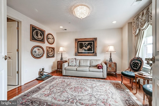 living area with baseboards, visible vents, and wood finished floors