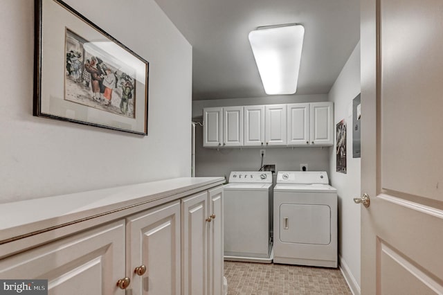 laundry room with baseboards, washing machine and dryer, and cabinet space