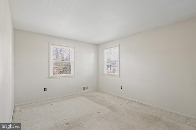 carpeted empty room with visible vents and baseboards