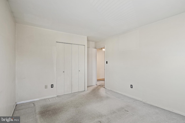 unfurnished bedroom featuring carpet and a closet