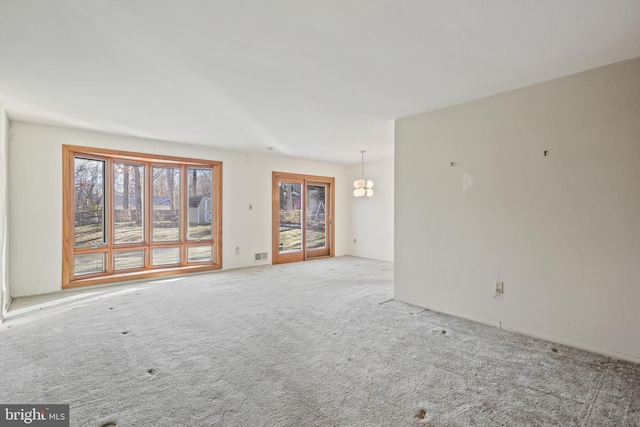 unfurnished room featuring visible vents and light colored carpet