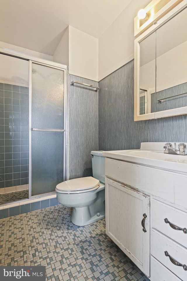 bathroom featuring a stall shower, a wainscoted wall, vanity, and toilet