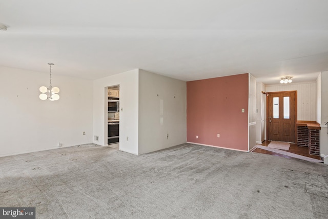 unfurnished living room with a chandelier and carpet flooring