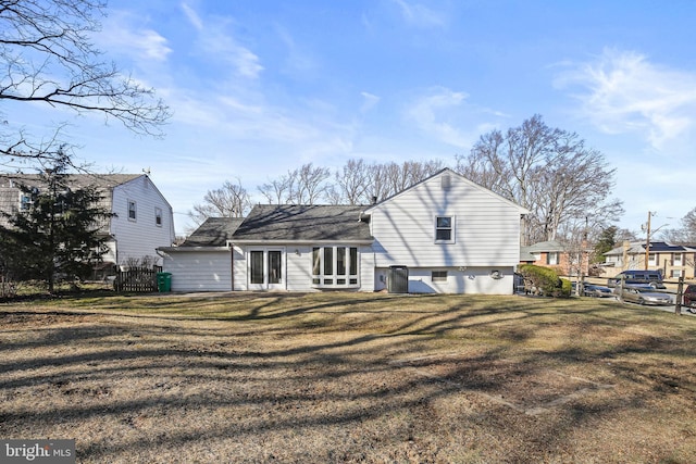 rear view of house with a yard and fence